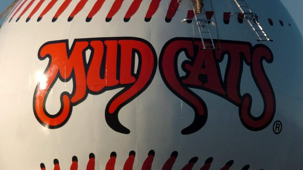 MUDCATS1.SP.041604.CCS---HAVIN’ A BALL-- Workers put the finishing touches on one of the new additions for the Mudcats -- a giant baseball painted on the water tower near the stadium on Friday evening 4/16. The Mudcats play its home opener against Birmingham Friday night. staff/Chris Seward