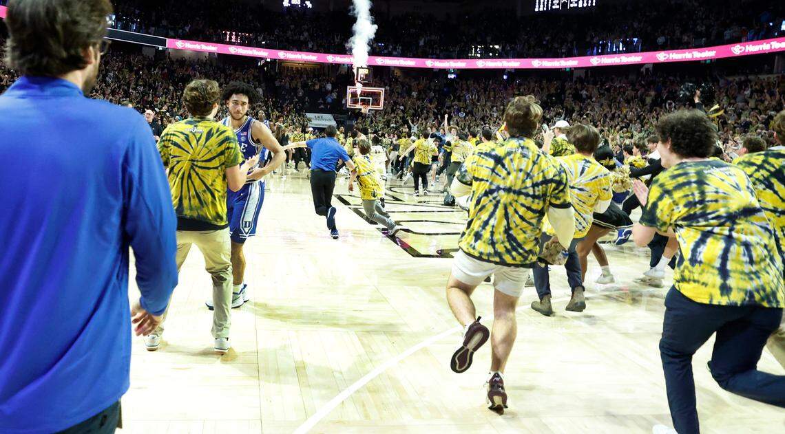 Duke’s Jared McCain (0), left, walks off as the fans rush the court after Wake Forest’s 83-79 victory over Duke at Lawrence Joel Veterans Memorial Coliseum in Winston-Salem, N.C., Saturday, Feb. 24, 2024.