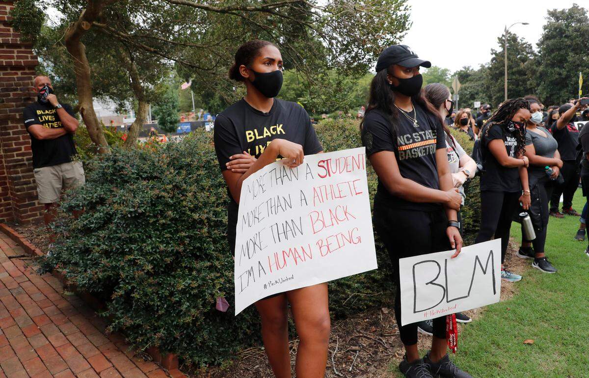 N.C. State athletes, coaches and staff listen to the speakers during a #PackUnited peaceful protest against racial and social injustice outside Holladay Hall on the campus of N.C. State Saturday, Sept. 12, 2020.