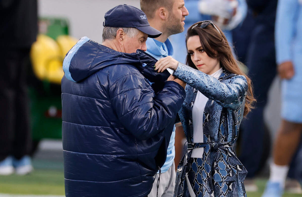 Jordon Hudson helps North Carolina head football coach Bill Belichick put on a mic before UNC football’s Practice Like a Pro open practice at Kenan Stadium in Chapel Hill, N.C., Saturday, April 12, 2025.