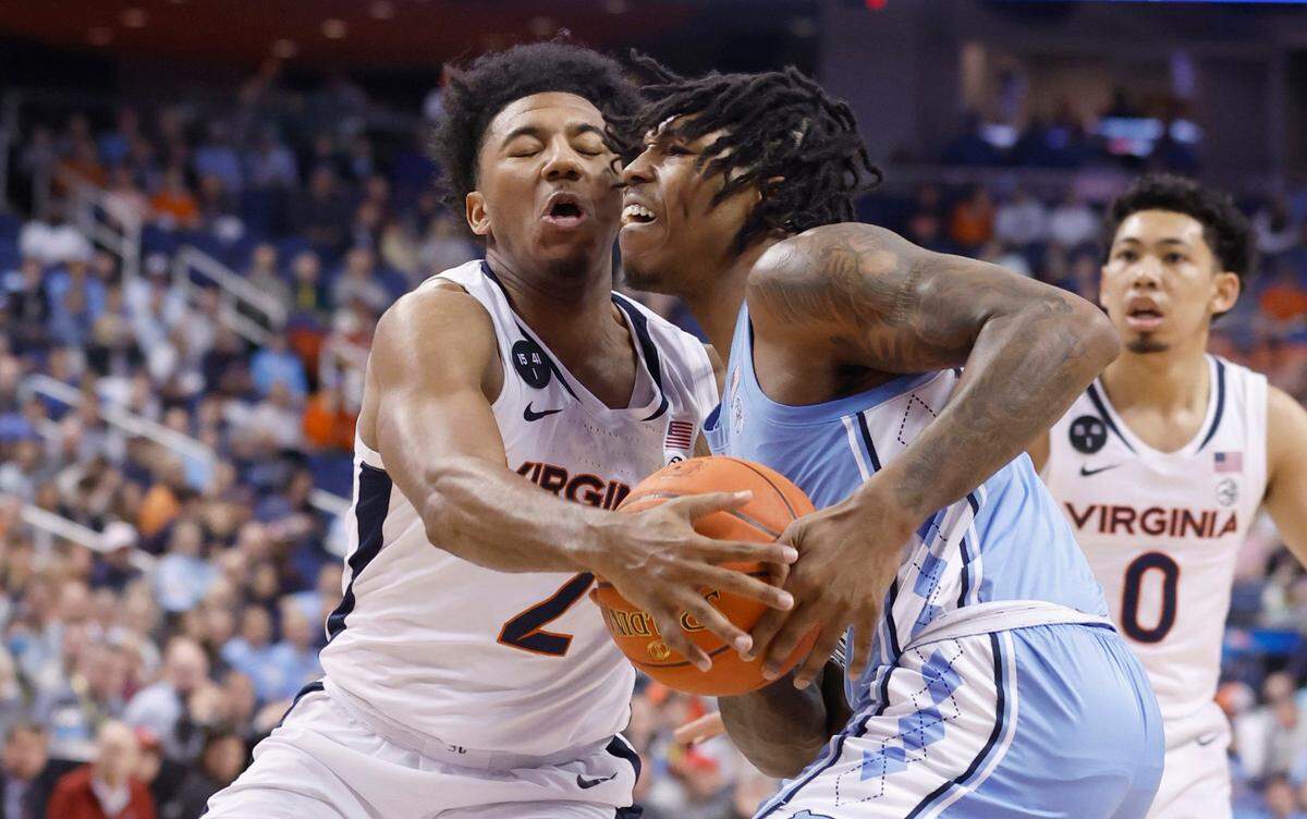 Virginia’s Reece Beekman (2) strips the ball from North Carolina’s Caleb Love (2) during the first half of UNC’s game against Virginia in the quarterfinals of the ACC Men’s Basketball Tournament in Greensboro, N.C., Thursday, March 9, 2023.