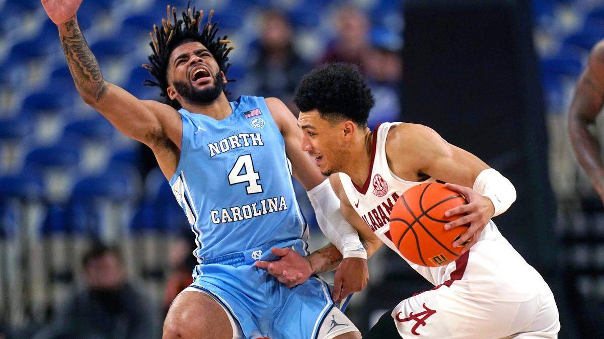 North Carolina guard R.J. Davis (4) fouls Alabama guard Jahvon Quinerly during the first half of an NCAA college basketball game in the Phil Knight Invitational on Sunday, Nov. 27, 2022, in Portland, Ore. (AP Photo/Rick Bowmer)