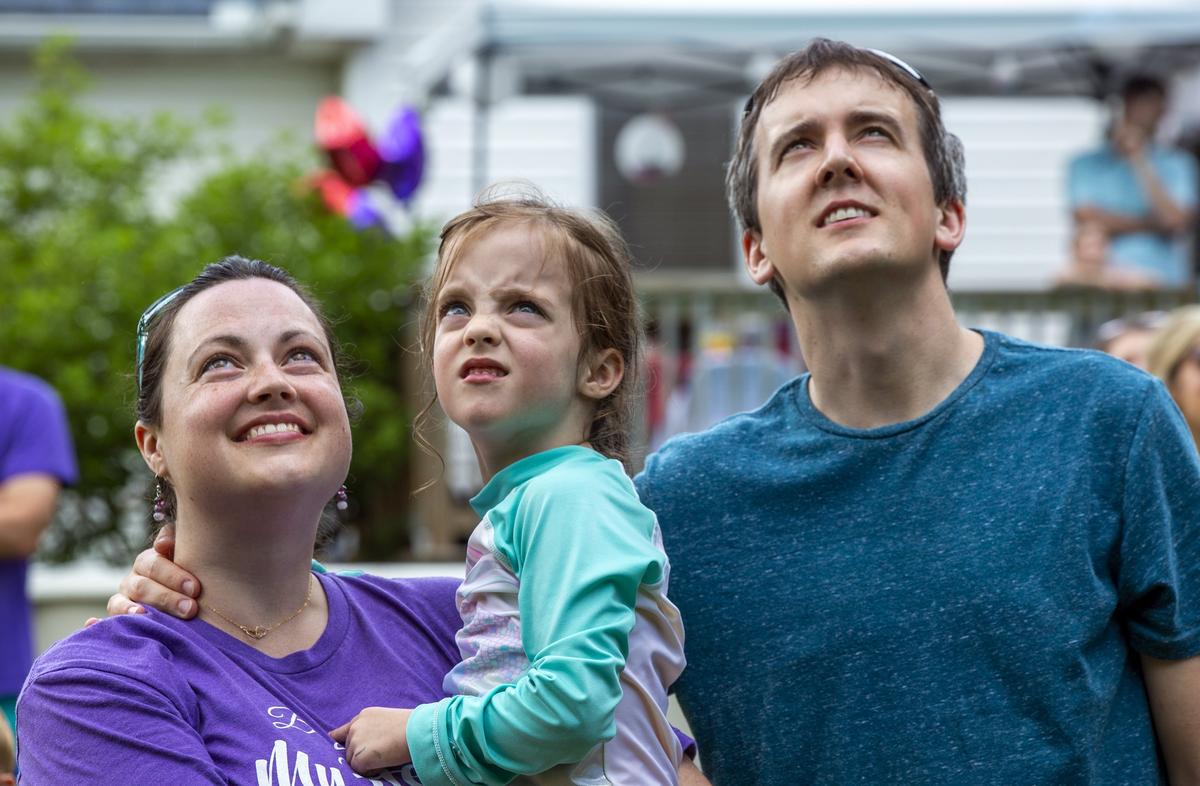 From left, Emily, Rebekah, and Andy Neill watch a paper lantern drift up to the sky for Rebekah’s twin sister Avery who died on Mother’s Day, May 13, 2018, of an incurable brain tumor known as DIPG, during the sixth birthday part they would’ve shared on Saturday, Jun. 2, 2018, in Raleigh, NC.