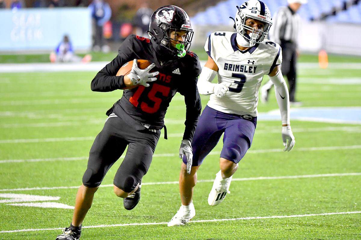 Rolesville wide receiver AJ Roberts (15) runs for the touchdown ahead of Grimsley’s Kosci Barnes (3) during the first half. The Rolesville Rams and the Greensboro Grimsley Whirlies met in the NCHSAA 4A football Championship Game in Chapel Hill, N.C. on December 20, 2024.