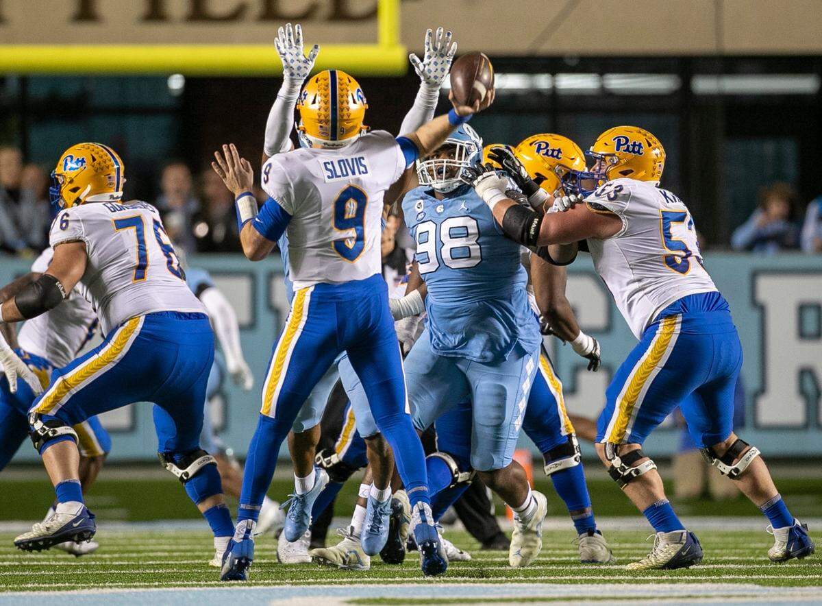 Pitt quarterback Kedon Slovis (9) is pressured by North Carolina’s Cedric Gray (33) in the first quarter on Saturday, October 29, 2022 at Kenan Stadium in Chapel Hill, N.C.
