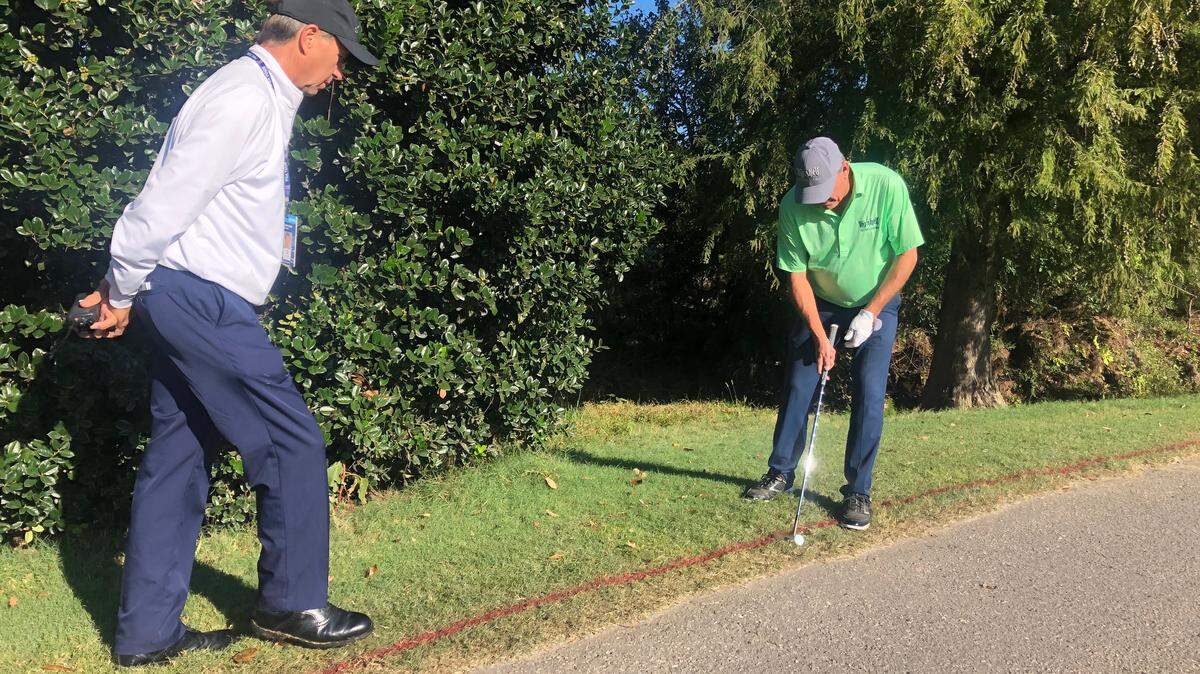 PGA Tour Champions rules official Brian Claar, left, discusses with golfer Neal Lancaster his options for relief after his tee shot on the 11th hole Friday landed near a cart path. Claar is one of seven roving rules officials at Prestonwood Country Club in Cary for the SAS Championship this weekend.