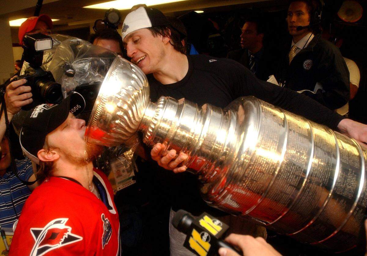 Carolina Hurricanes teammate Eric Staal drinks from the Stanley Cup being tip by Rod Brind'Amour in the lockerroom after beating the Edmonton Oilers 3-1 on Monday, June 19, 2006 during game 7 of the Stanley Cup Final. 