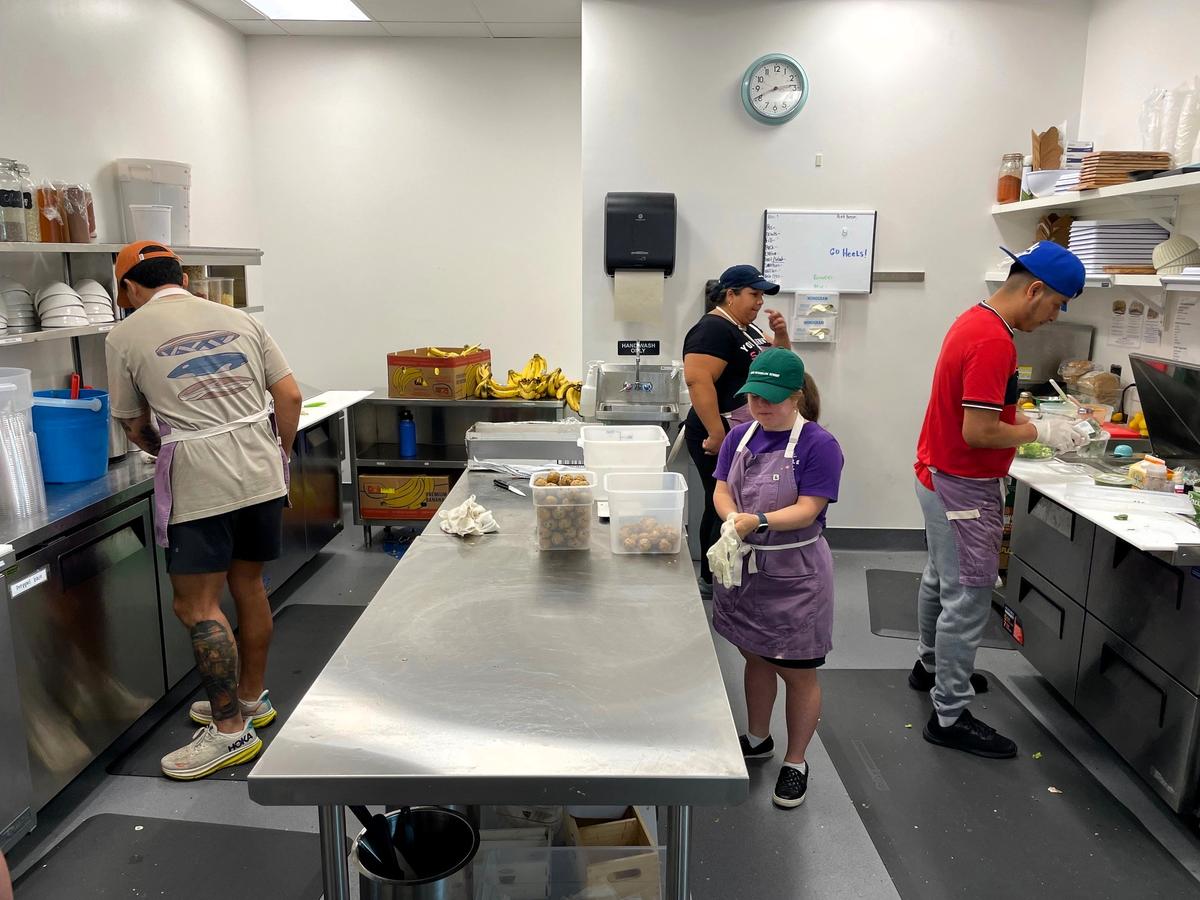Purple Bowl staff, including Lucia Romano (center), Rocio Patino (rear) and kitchen manager Kevin Gomez (right), prepare salads, energy balls and other menu items after the Wednesday afternoon lunch rush on Oct. 3, 2024, in Chapel Hill, NC.