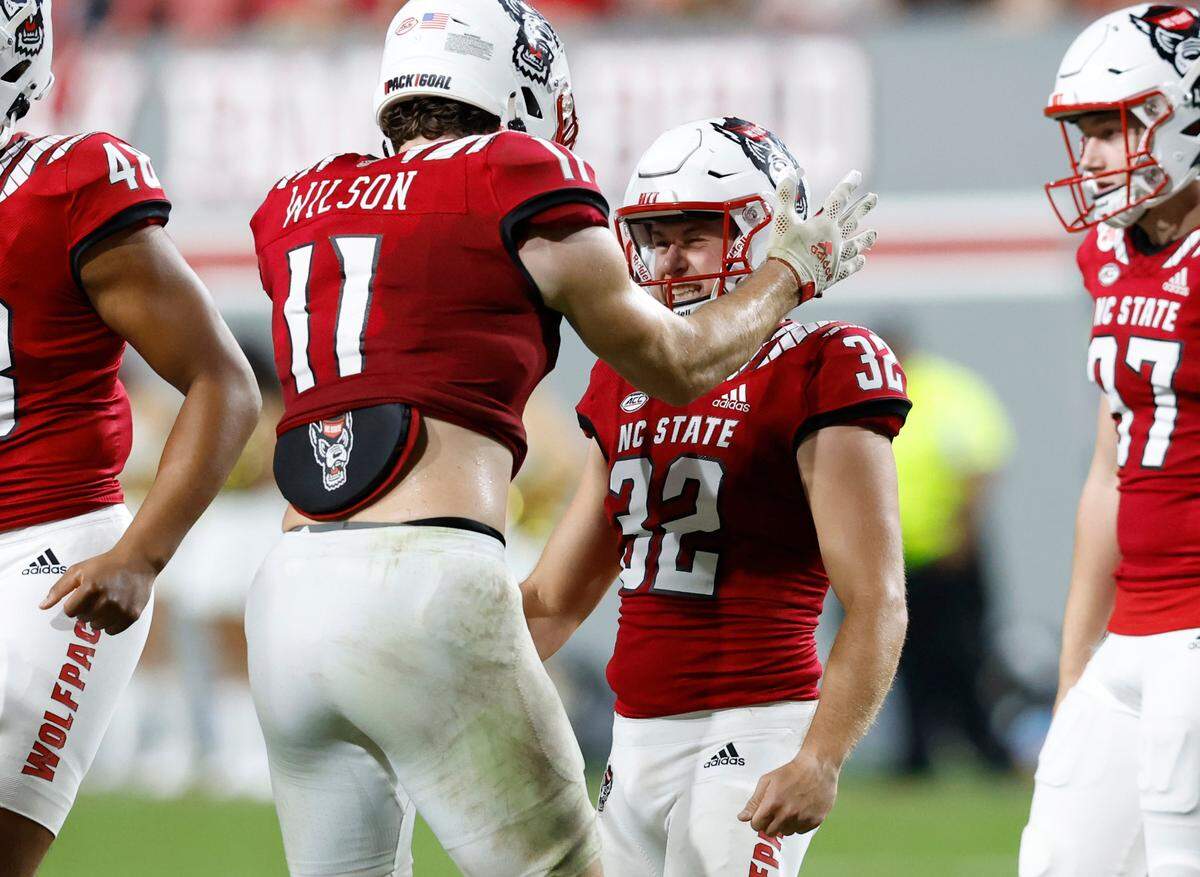N.C. State linebacker Payton Wilson (11) congratulates kicker Christopher Dunn (32) after he hit a 51-yard field goal during the second half of N.C. State’s 30-21 victory over Wake Forest at Carter-Finley Stadium in Raleigh, N.C., Saturday, Nov. 5, 2022.