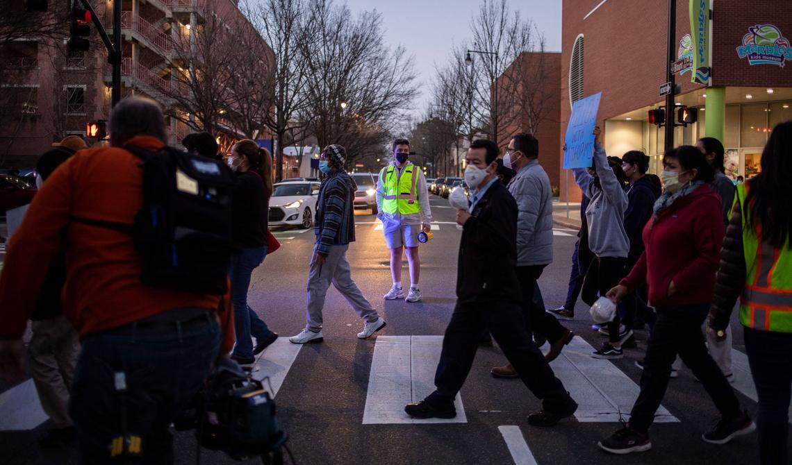 An organizer waits for marchers to cross a street in downtown Raleigh, N.C. during a march for Daniel Turcios, who was shot and killed by Raleigh police in January, on Thursday, Feb. 10, 2022.