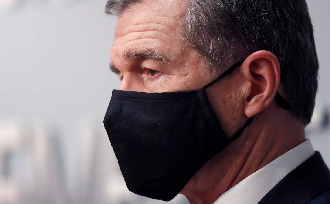 Gov. Roy Cooper listens as  Dr. Mandy Cohen, Secretary of the N.C. Department of Health and Human Services, speaks during a briefing at the Emergency Operations Center in Raleigh, N.C., Tuesday, Sept. 1, 2020.
