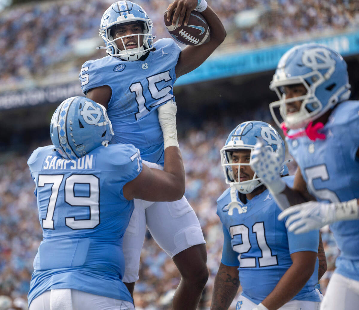 North Carolina offensive lineman Howard Sampson (79) hoists quarterback Conner Harrell (15) in the air after Harrell scored on a 4-yard run in the second quarter against Charlotte on Saturday, September 7, 2024 at Kenan Stadium in Chapel Hill, N.C.