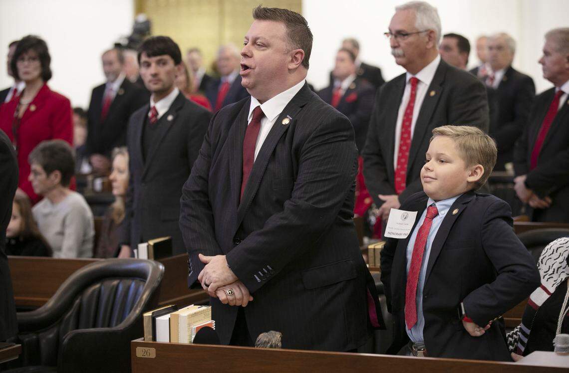 Jackson Saine, the ten-year-old son of Rep. Jason Saine of Lincolnton, N.C. stands beside his father during roll call on the opening say of the 2019-20 legislative session on Wednesday, January 9, 2019 in Raleigh, N.C.