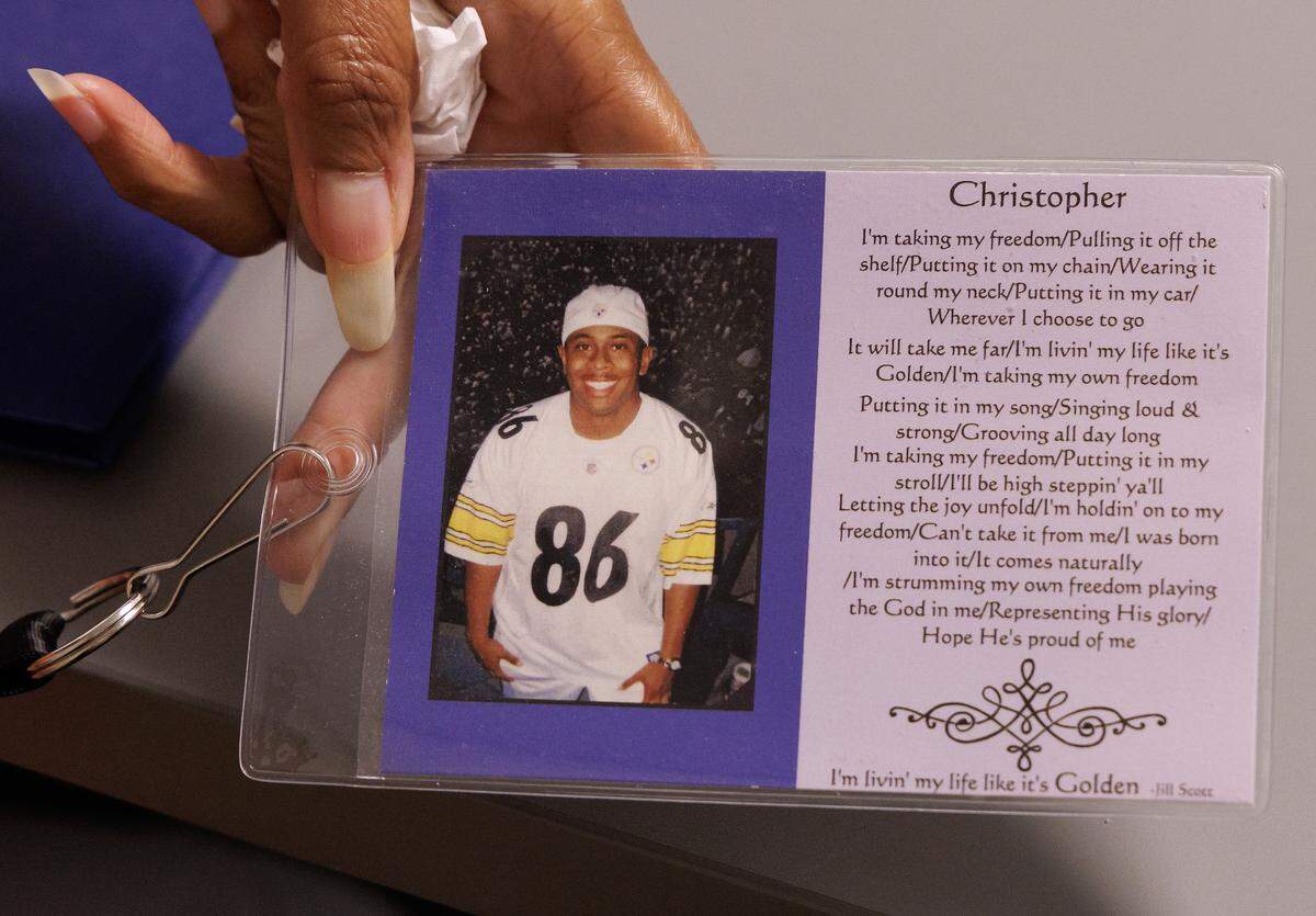 Marie Buggs, whose son, Christopher Miller, died by suicide, wears a lanyard with his photograph and the lyrics from “Golden” by Jill Scott.