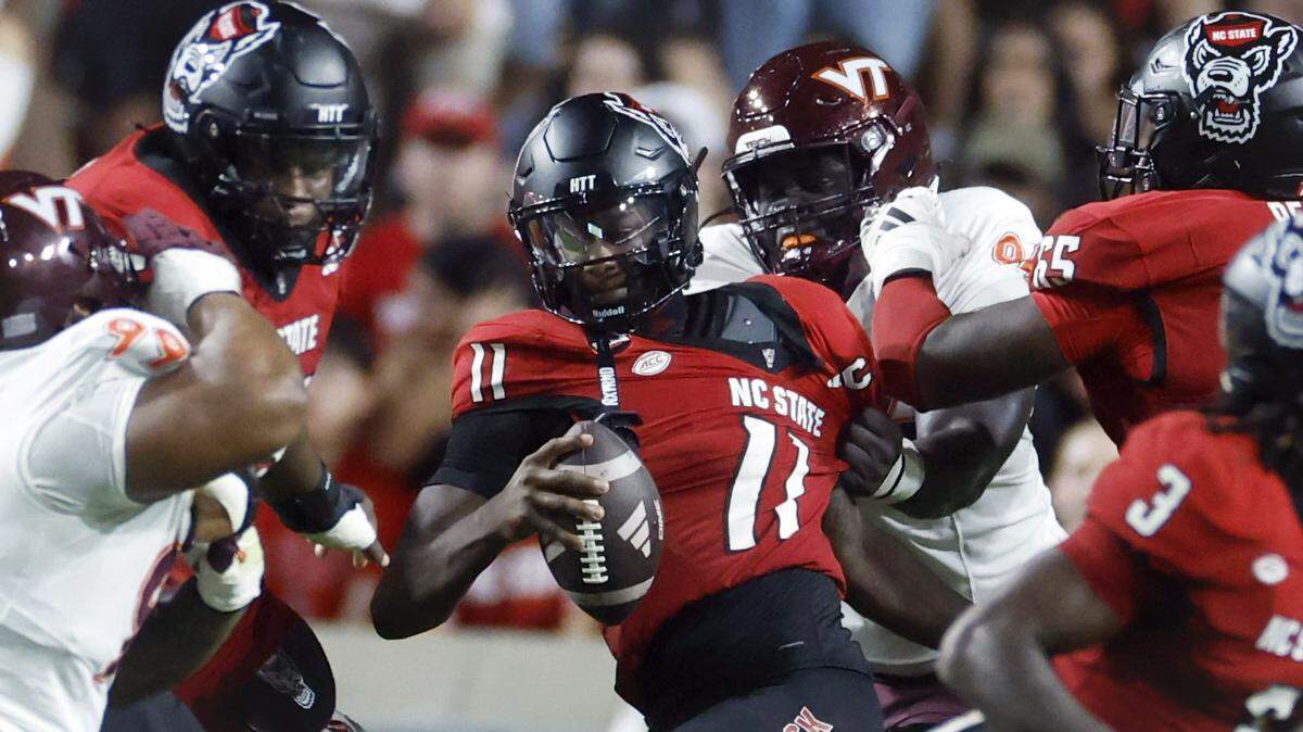 N.C. State quarterback CJ Bailey (11) is sacked by Virginia Tech defensive lineman Elhadj Fall (94) during the first half of N.C. State’s game against Virginia Tech at Carter-Finley Stadium in Raleigh, N.C., Saturday, Sept. 27, 2025.