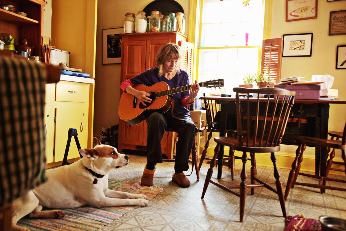 Alice Gerrard plays at her kitchen table in Durham in 2015, as her dog, Polly, sits at her feet. During Wide Open Bluegrass, there will be a tribute to Alice Gerrard and the late Hazel Dickens.