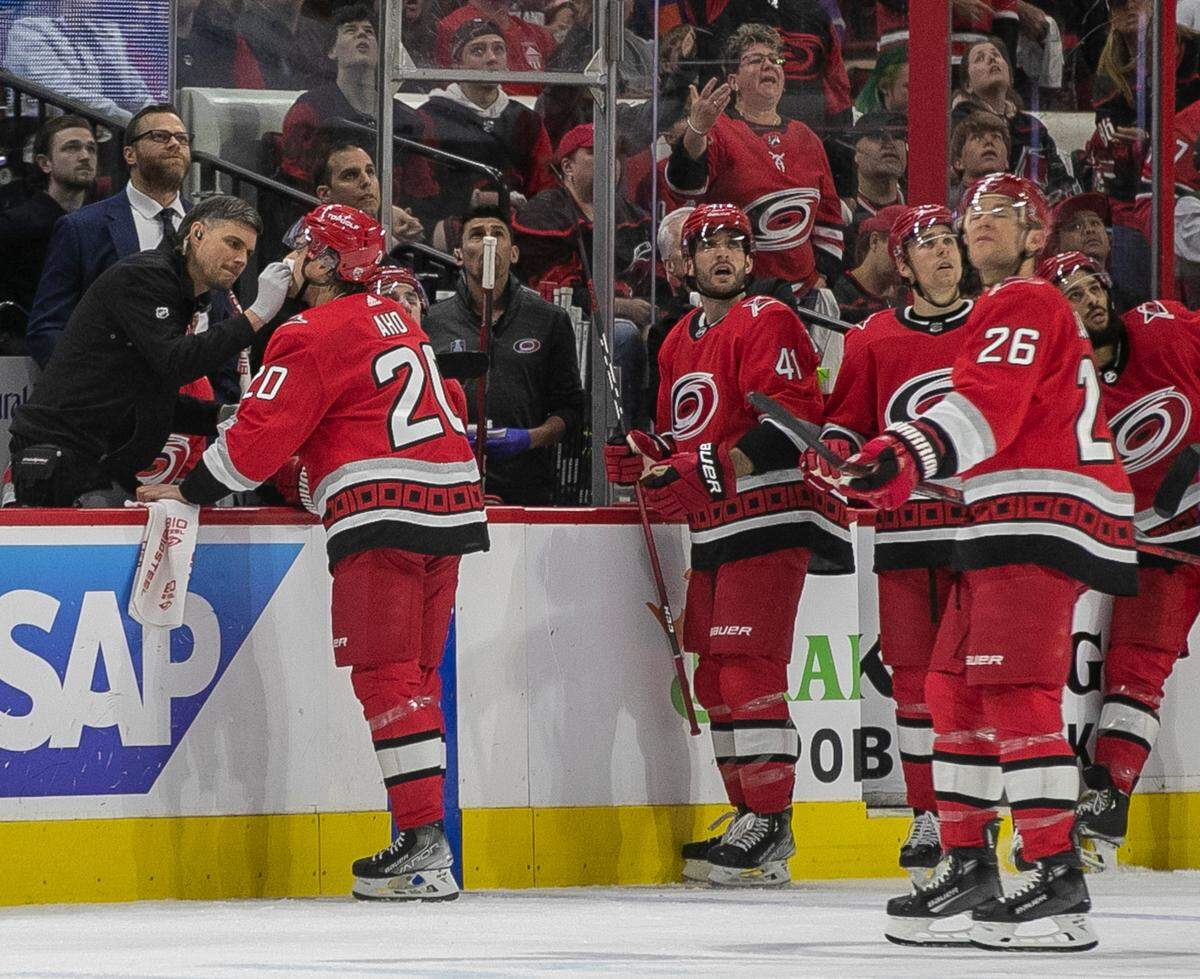 The Carolina Hurricanes Sebastian Aho (20) is attended to by a trainer after being high-sticked in the face in the first period during Game 2 of their Stanley Cup series on Wednesday, April 19, 2023 at PNC Arena in Raleigh, N.C.