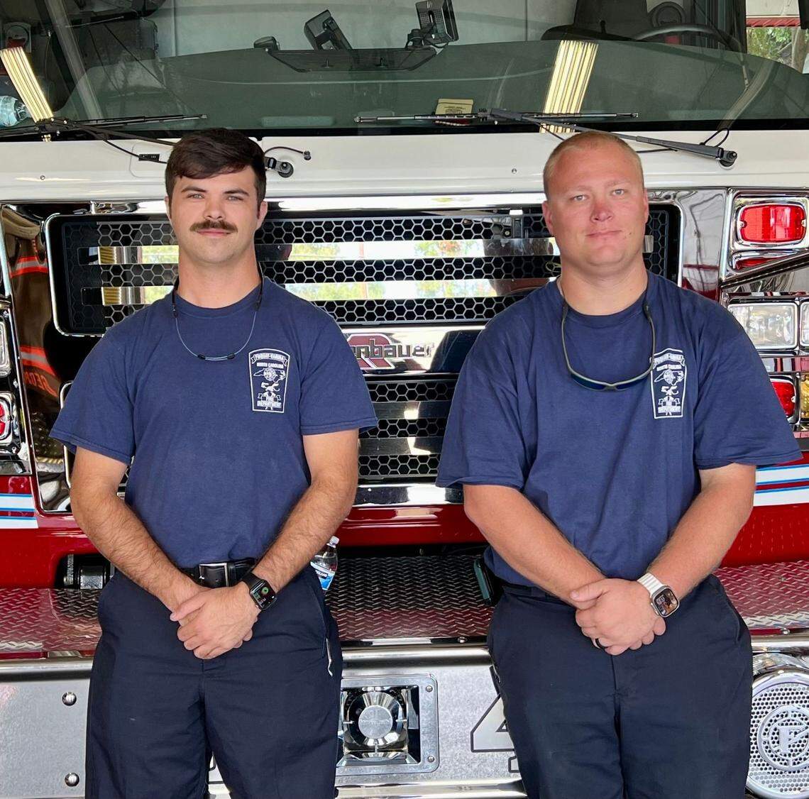 Fuquay-Varina firefighters Caleb Thompson, left, and Hunter Hartley, right, pose in front of their fire truck. Thompson and Hartley were sent to Polk County on Oct. 2, 2024, to assist in Hurricane Helene recovery efforts.
