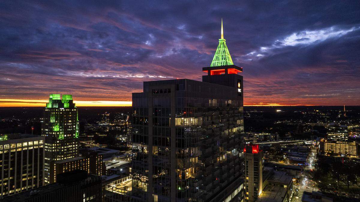 A vivid winter sunset sets over downtown Raleigh on Monday, Dec. 22, 2025 as the low angle of the sun intensifies the evening light. The 538-foot-tall PNC Plaza rises above the skyline illuminated in red and green for the holidays. The winter solstice has passed and the days are beginning to grow longer.
