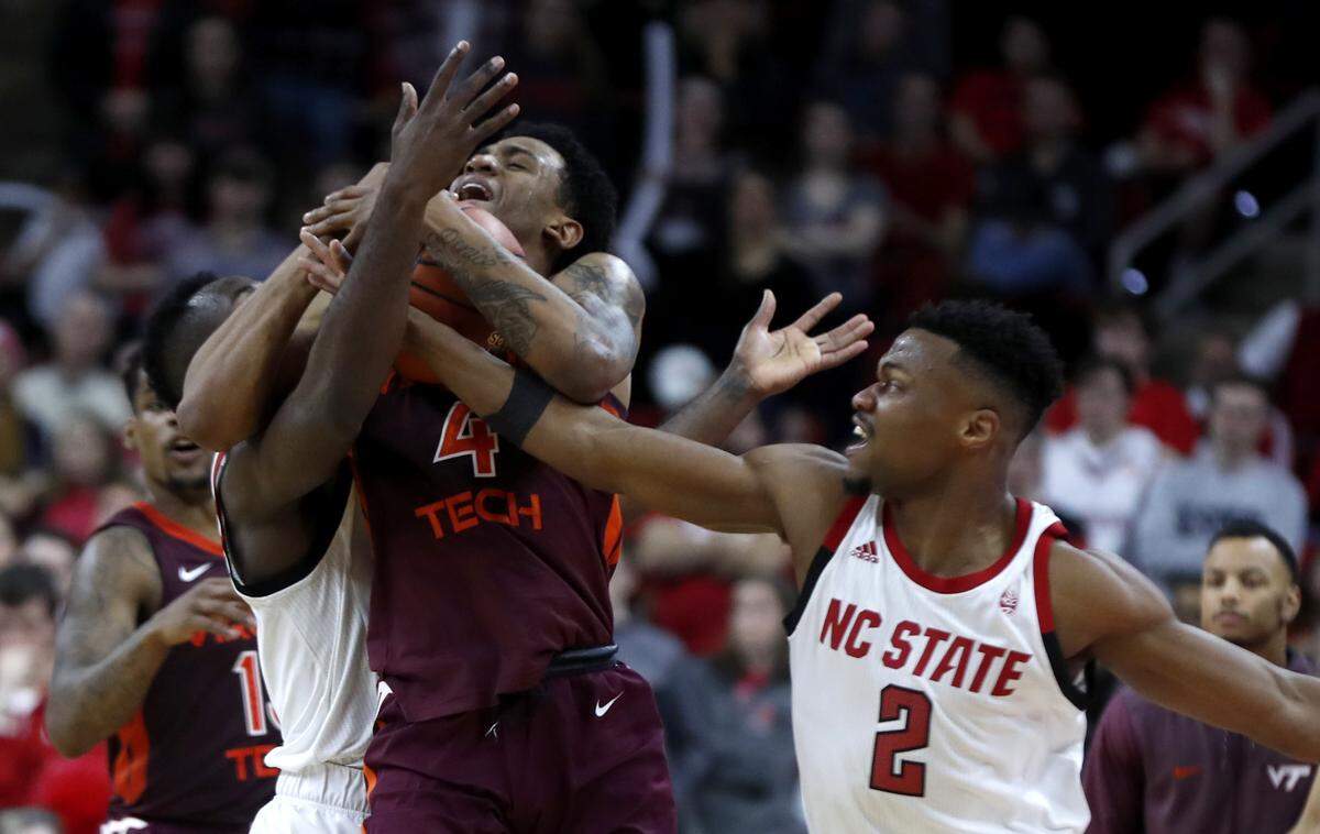 N.C. State’s Torin Dorn (2), right, and Eric Lockett (5) pressure Virginia Tech’s Nickeil Alexander-Walker (4) during the second half of Virginia Tech’s 47-24 victory over N.C. State at PNC Arena in Raleigh, N.C., Saturday, Feb. 2, 2019.