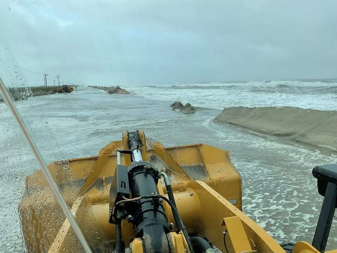 N.C. DOT crews worked to clear water and sand from N.C. 12 on Sunday, after a nor’easter’s high winds and waves pushed sand and water onto the highway, blocking travel along the Outer Banks.