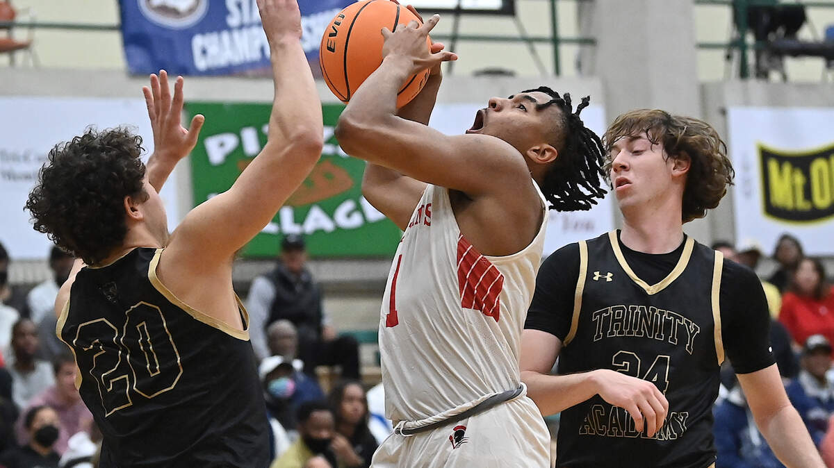 Trinity Academy’s Trey Barker (20) and Sam Perez (24) defend The Burlington School’s Zion Walker (1) in the first half. The Burlington School Spartans and the Trinity Academy Tigers met in the NCISAA 2A boys Final in Mt. Olive, N.C. on February 26, 2022. The Burlington School wins 57-45.
