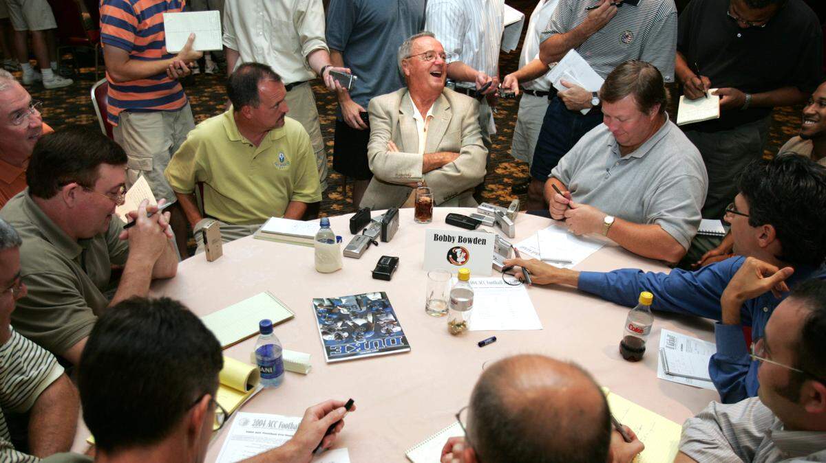 Florida State football coach Bobby Bowden, center with arms folded, talks to reporters during the 2004 ACC Football Kickoff on Monday, July 26, 2004, at Grandover Resort in Greensboro.