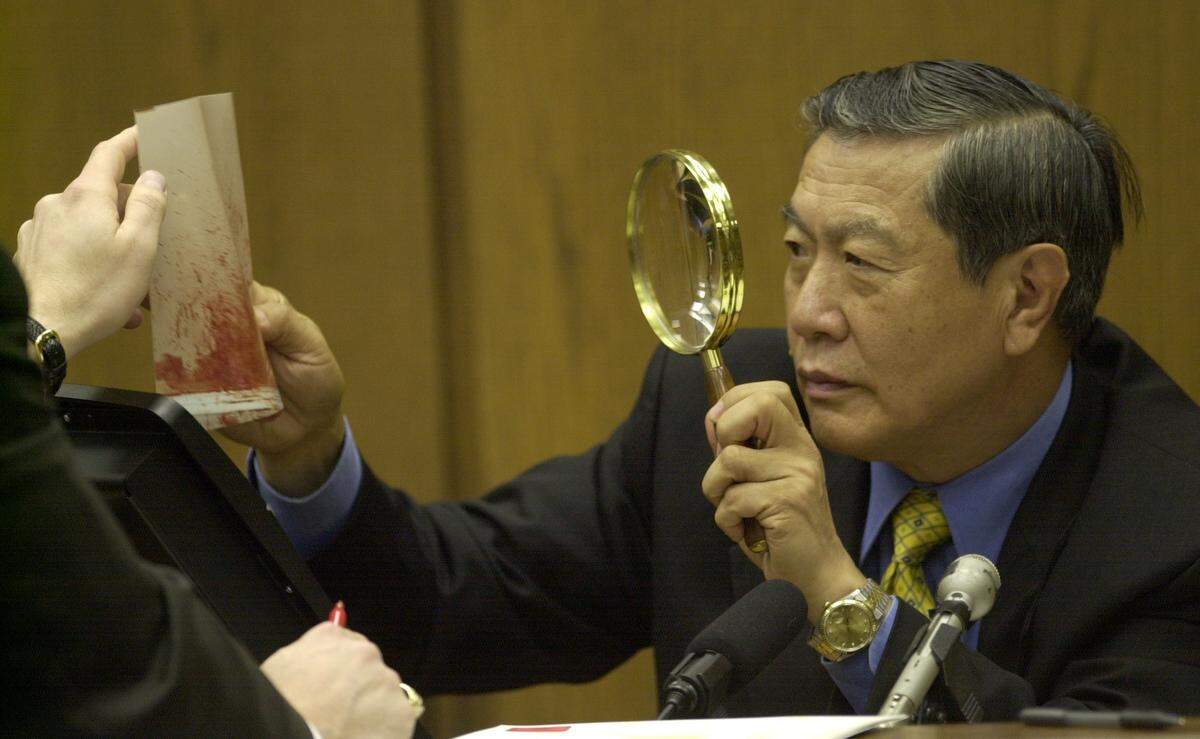 Henry C. Lee, prominent forensics expert takes a closer look at a blood spatter evidence photo during the prosecution's cross-examination of Lee as to his interpretation of the evidence during Monday afternoon at the Michael Peterson murder trial in November 2003.