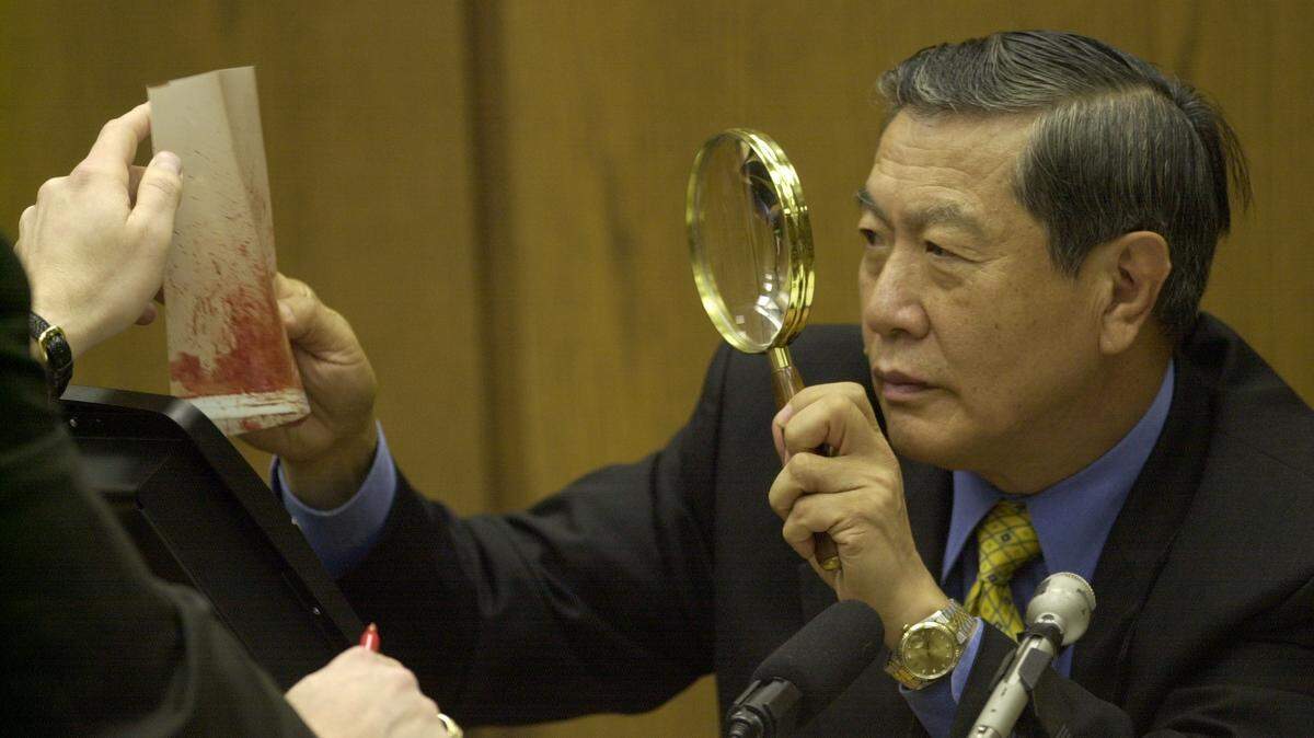 Henry C. Lee, prominent forensics expert takes a closer look at a blood spatter evidence photo during the prosecution's cross-examination of Lee as to his interpretation of the evidence during Monday afternoon at the Michael Peterson murder trial in November 2003.