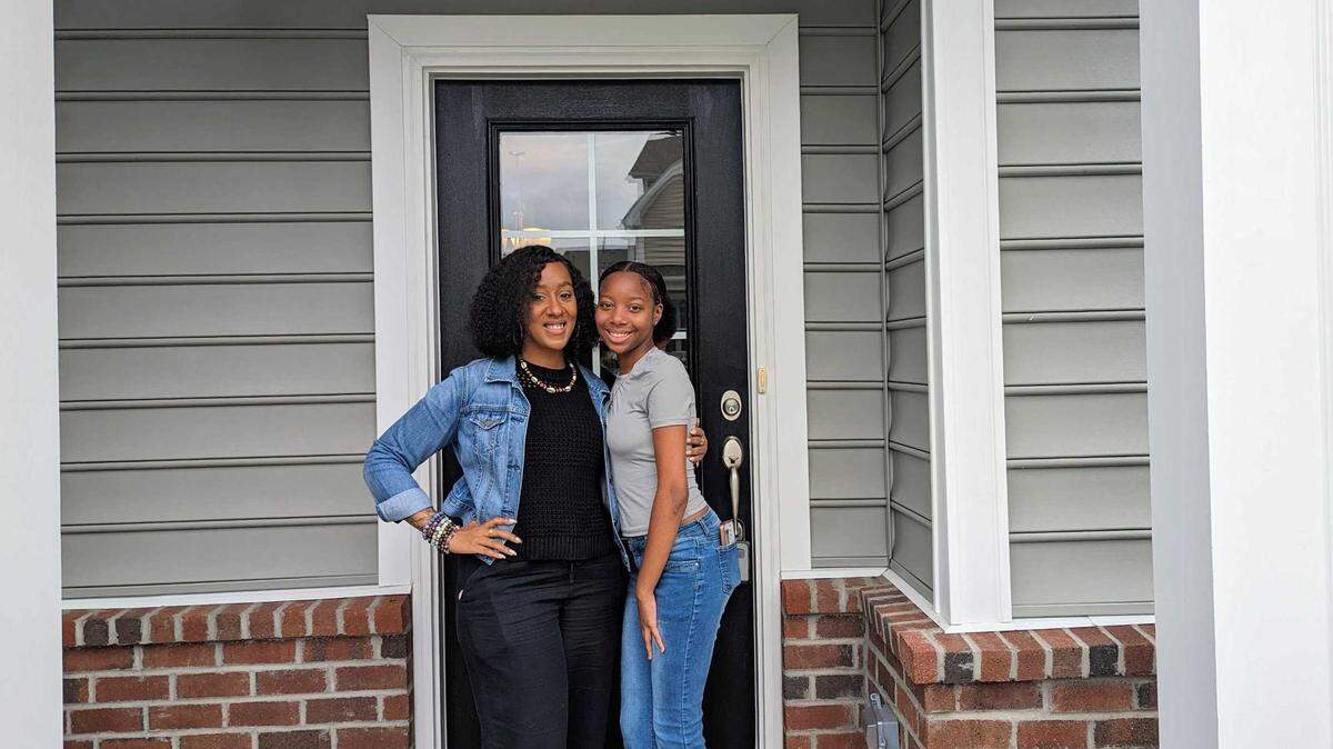 First-time homeowner Desirae Lewis is pictured with her daughter, Jaliyah W., in front of her new townhouse in Brier Creek in Raleigh. She purchased the home using an alternative-financing model offered by Durham-based real estate startup, Acre.