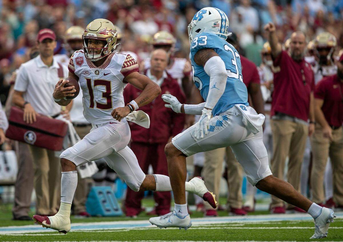 Florida State quarterback Jordan Travis (13) picks up six yards ahead of North Carolina’s Cedric Gray (33) in the third quarter on Saturday, October 9, 2021at Kenan Stadium in Chapel Hill, N.C.