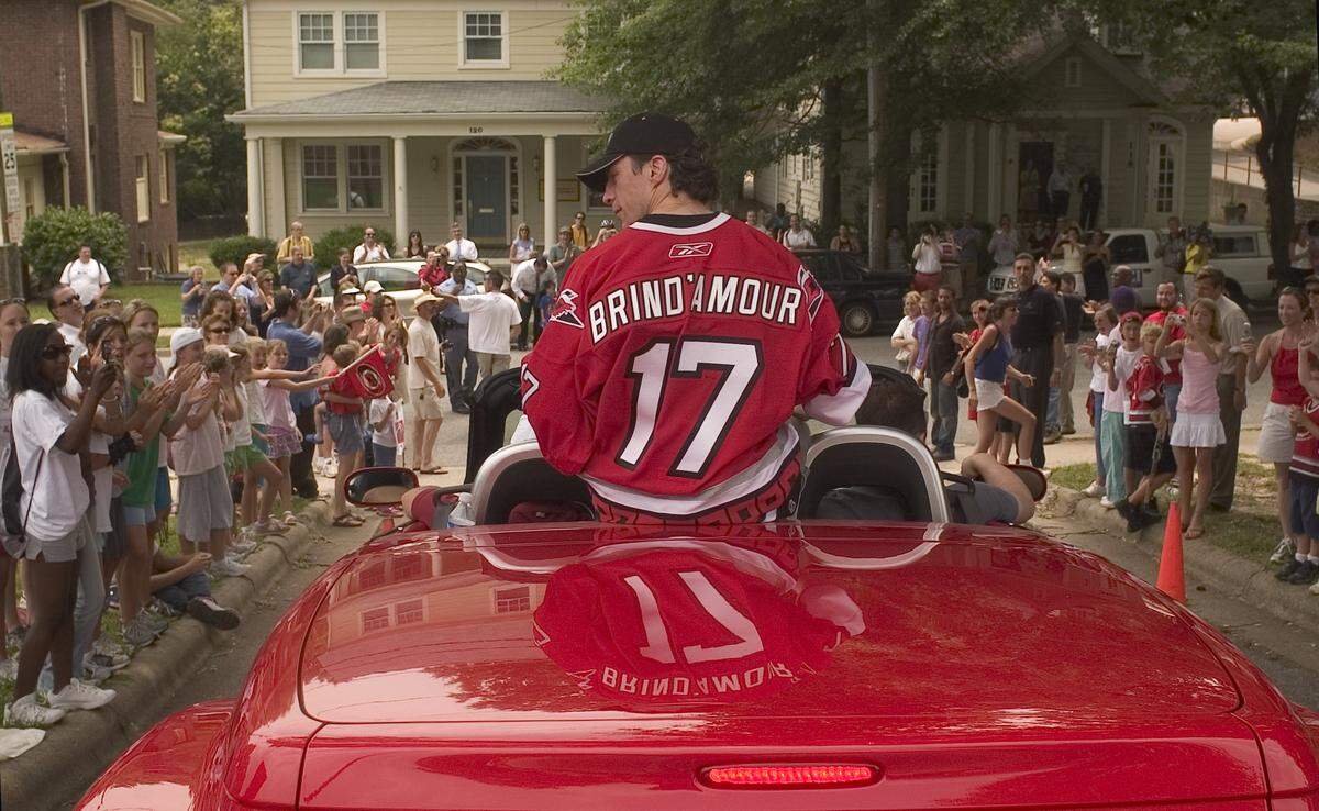 Hurricanes captain Rod Brind’Amour rides in a red convertible as the victory parade for the Stanley Cup Champions begins at St. Mary’s School on St. Mary’s Street on June 21, 2006.