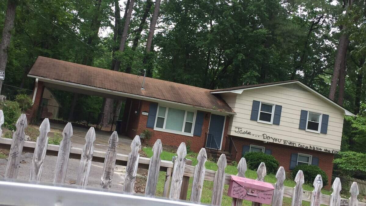 "J. Cole ... Do you even care about the Ville?" in black spray paint on the front of J. Cole's Forest Hills Drive home in Fayetteville.