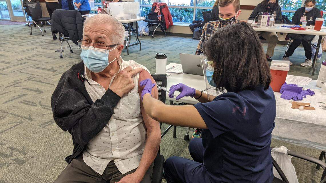 Nandini Kumar, 33, of Duke Primary Care administering a dose of the COVID-19 vaccine to Teofilo Dasilva, 69, of Raleigh.