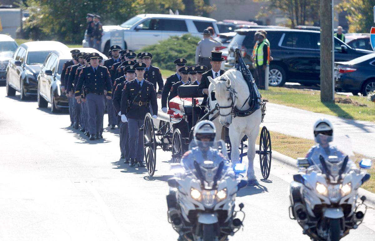 A funeral caisson transports the casket of Raleigh Police Officer Gabriel Torres down Yonkers Road to Cross Assembly Church in Raleigh, N.C. for his funeral Saturday, Oct. 22, 2022. Officer Torres was killed during a mass shooting Oct. 13.