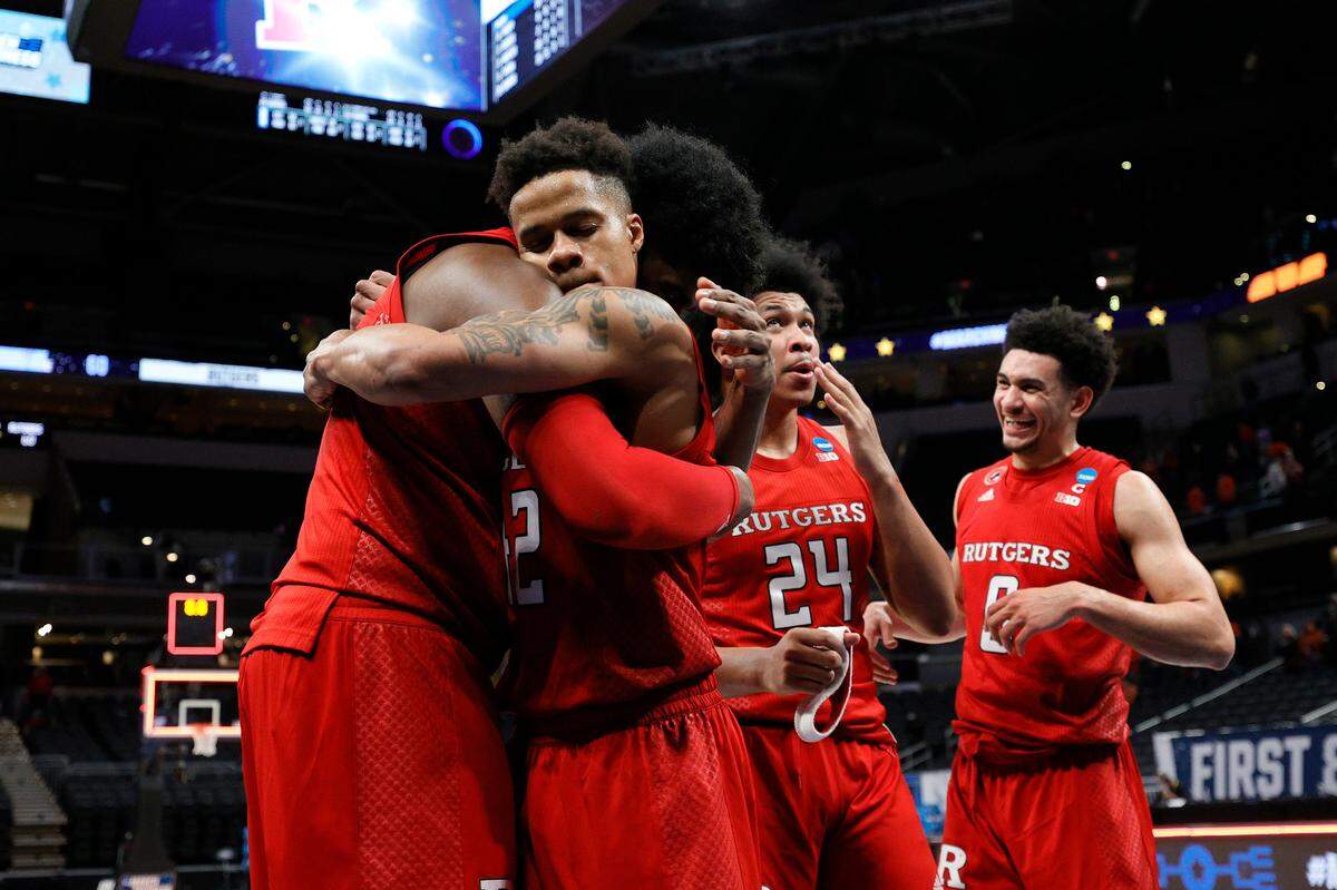 The Rutgers Scarlet Knights celebrate after defeating the Clemson Tigers in the first-round game of the 2021 NCAA Men’s Basketball Tournament at Bankers Life Fieldhouse on March 19, 2021 in Indianapolis, Indiana. Rutgers defeated Clemson 60-56. 