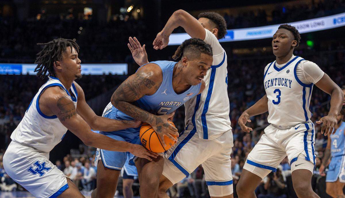 North Carolina’s Armando Bacot (5) works to secure an offensive rebound against Kentucky’s D.J. Wagner (21), Tre Mitchell (4) and Adou Thiero (3) in the second half on Saturday, December 16, 2023 at State Farm Arena in Atlanta, Georgia.