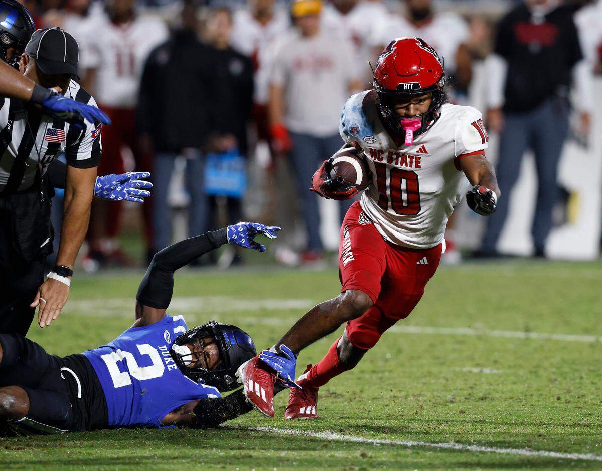 N.C. State’s Kevin Concepcion runs the ball past Duke’s Jaylen Stinson during the second half of the Blue Devils’ 24-3 win on Saturday, Oct. 14, 2023, at Wallace Wade Stadium in Durham, N.C.