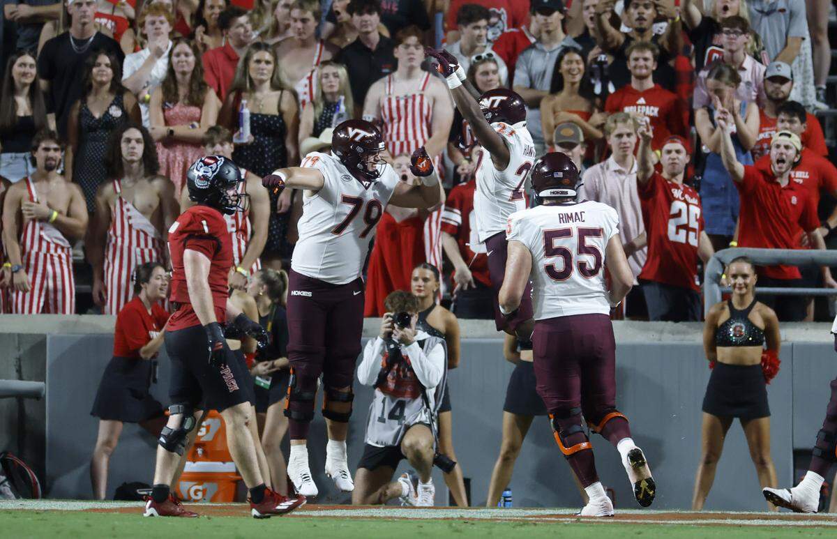 Virginia Tech running back Marcellous Hawkins (27) celebrates with offensive lineman Johnny Garrett (79) after scoring during the first half of N.C. State’s game against Virginia Tech at Carter-Finley Stadium in Raleigh, N.C., Saturday, Sept. 27, 2025.