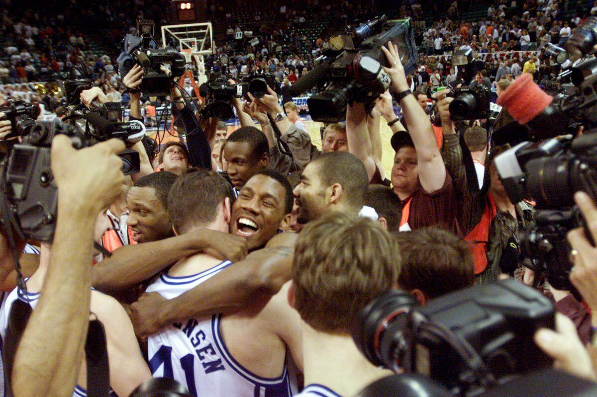 Duke's Nate James hugs teammate Matt Christensen as his teammates and the media move in after  Duke beat Maryland, 81-68, to win the ACC Tournament.