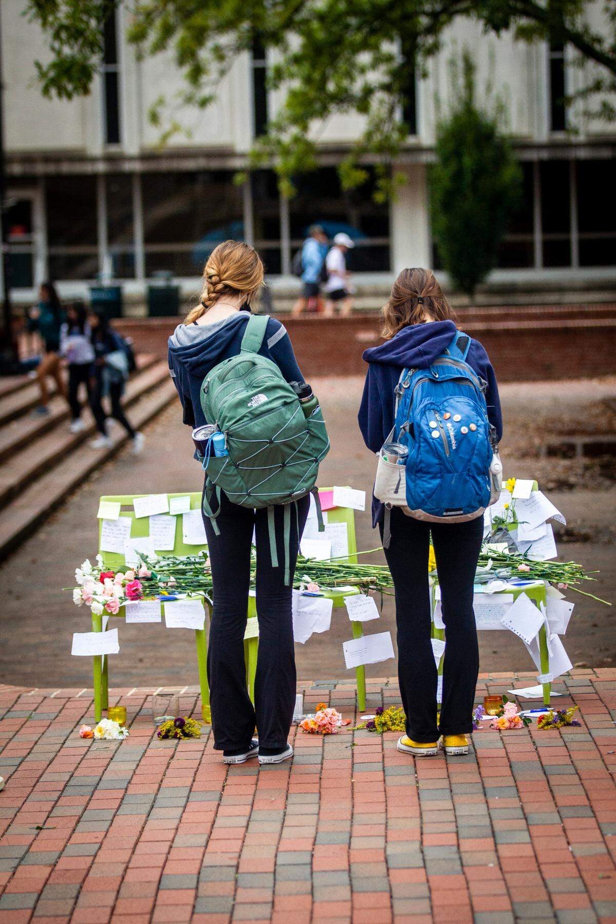 Students pause in front of a makeshift memorial on The Pit at UNC-Chapel Hill Monday, Oct. 11, 2021. University officials canceled classes Tuesday after police investigated multiple reports of suicide since the start of classes this fall.