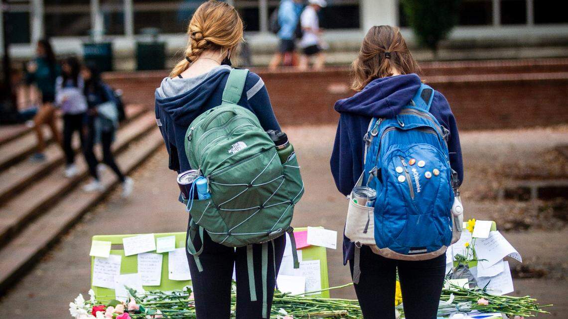 Students pause in front of a makeshift memorial on The Pit at UNC-Chapel Hill Monday, Oct. 11, 2021. University officials canceled classes Tuesday after police investigated multiple reports of suicide since the start of classes this fall.