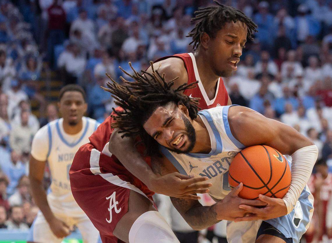 Alabama forward Derrion Reid (35) smothers North Carolina guard R.J. Davis (4) with defense in the second half on Wednesday, December 4, 2024 at the Smith Center in Chapel Hill, N.C.