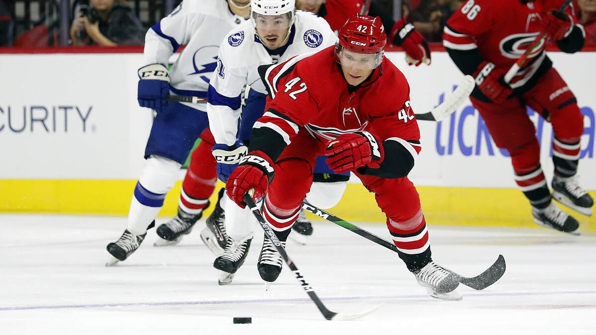 Carolina Hurricanes defenseman Gustav Forsling (42), stretches for the puck while being pursued by Boris Katchouk (41) of the Tampa Bay Lightning during the first period of Wednesday’s preseason home opener. Forsling was one of five newcomers in the Carolina lineup.