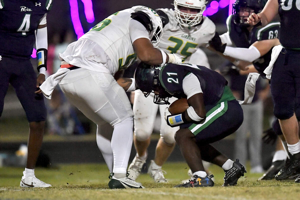 Cardinal Gibbons defensive tackle Chris Pinder (56) grapples Leesville Road’s AkShar Barnes (21) during the first half. The Leesville Road Pride and the Cardinal Gibbons Crusaders met in a conference football game in Raleigh, N.C. on November 1, 2024.