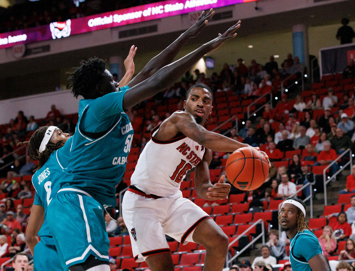 N.C. State’s Marcus Hill looks to pass around Coastal Carolina’s Mabor Majak during the first half of the Wolfpack’s game on Wednesday, Nov. 13, 2024, at Lenovo Center in Raleigh, N.C.