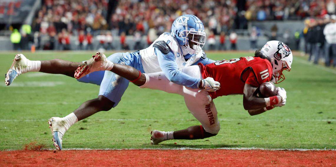 N.C. State wide receiver KC Concepcion (10) makes the reception as North Carolina defensive back Antavious Lane (1) defends during the first half of N.C. State’s game against UNC at Carter-Finley Stadium in Raleigh, N.C., Saturday, Nov. 25, 2023.