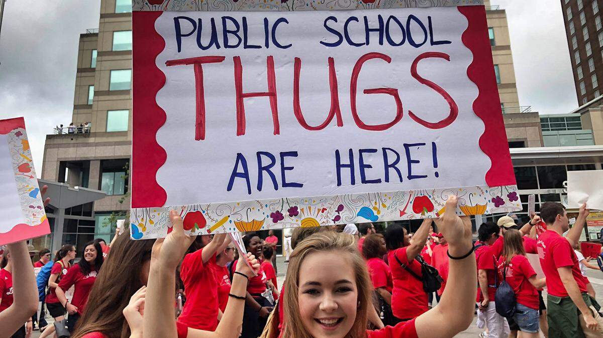 Teachers carry a sign sarcastically referring to a comment by Rep. Mark Brody earlier about "union thugs" coming to Raleigh for the teachers' march on the Legislature.