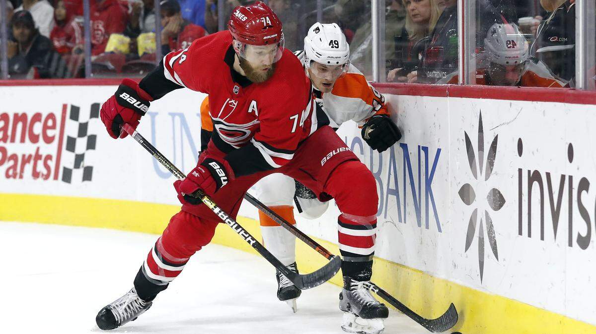 Carolina Hurricanes defenseman Jaccob Slavin (74) and Philadelphia Flyers left wing Joel Farabee (49) chase the puck during the first period of an NHL hockey game in Raleigh, N.C., Tuesday, Jan. 7, 2020.
