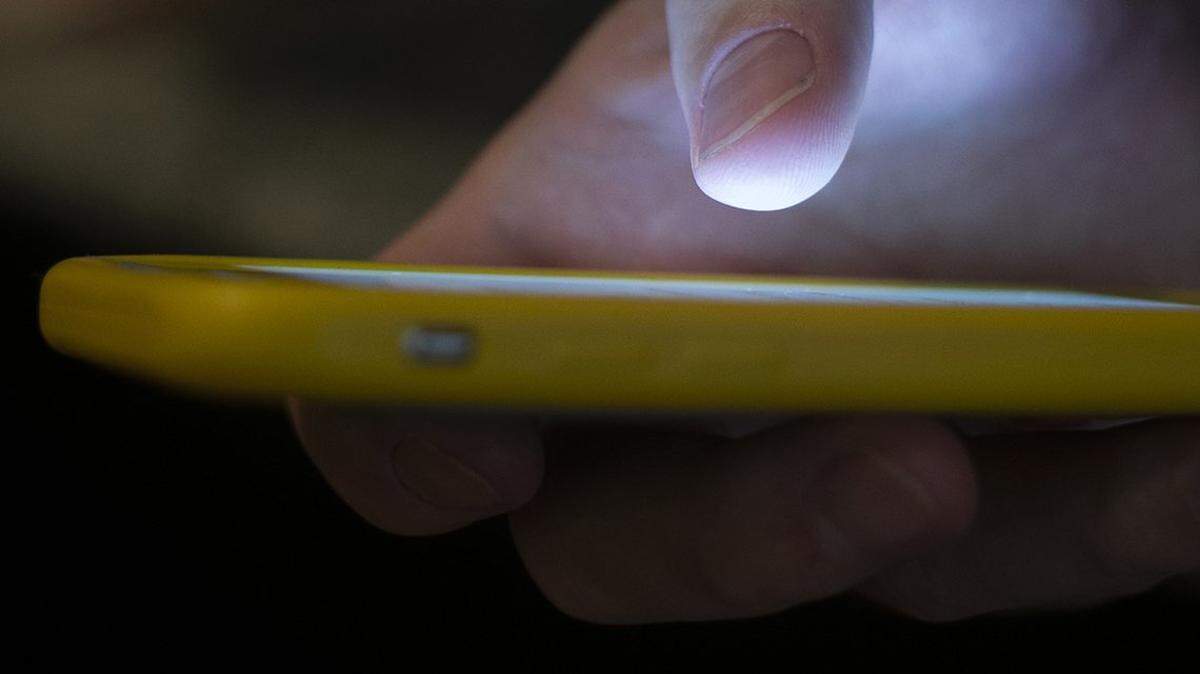FILE - In this Aug. 11, 2019, file photo, a man uses a cell phone in New Orleans. The Federal Communications Commission is setting up a new three-digit number to reach a suicide prevention hotline. Once it’s implemented, people will just need to dial 988 to seek help, similar to calling 911 for emergencies or 311 for city services.
